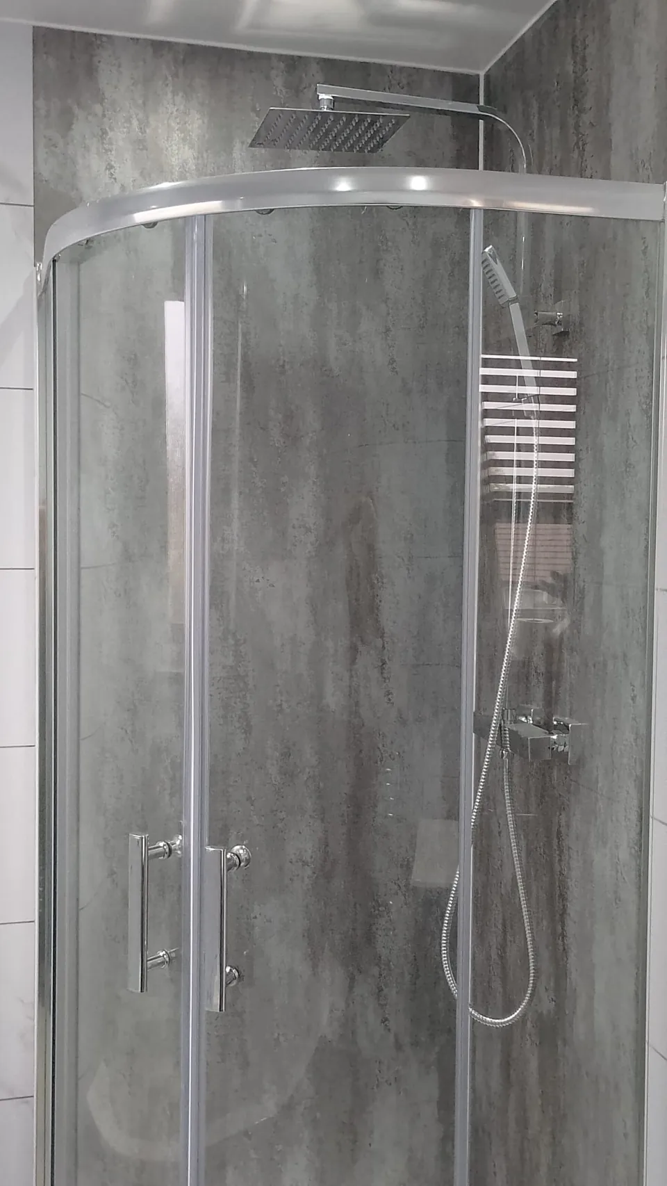 Curved glass shower enclosure with chrome fittings